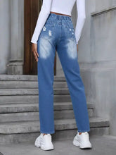 Back view of blue denim floral embroidered high waist distressed jeans with relaxed fit and patch details on pockets