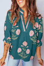Teal floral embroidered notched blouse with pink and green flowers, three-quarter sleeves, and v-neckline