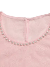 A delicate pink floral embroidered blouse with pearl trim along the neckline for elegant wear