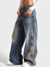 Floral embroidered wide leg denim jeans in faded blue with orange floral embroidery along the outer seam