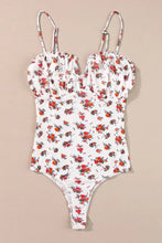 White one-piece swimsuit with floral frilled trim and trim spaghetti straps featuring red and orange floral ruched pattern