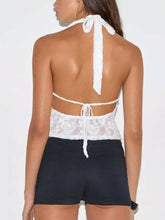 White floral lace halter neck cami with tied-back straps and decorative bow at neckline in delicate lace material