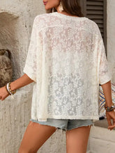 A delicate off-white floral lace sheer top with a loose fit and short sleeves featuring a round neck design