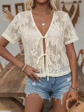 Off-white floral lace tie-front shirt with short sleeves featuring delicate floral lace tie detail