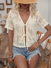 Cream-colored floral lace tie-front shirt featuring delicate floral lace patterns and a front tie detail