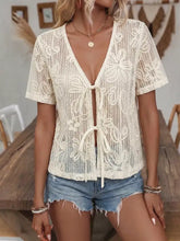 Cream-colored floral lace tie-front shirt featuring delicate floral lace patterns and a front tie detail