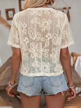 Cream-colored floral lace tie-front shirt with short sleeves featuring a delicate semi-transparent floral lace design