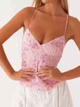A delicate pink floral lace neck cami with thin straps and embroidered floral patterns for elegant wear