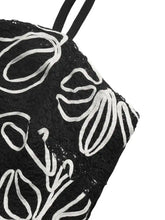 Black lace tote bag with white embroidered floral patterns and black handles complementing floral peplum cami style