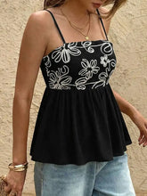 Black floral peplum cami with white embroidered floral patterns and a flattering peplum hem for stylish layering
