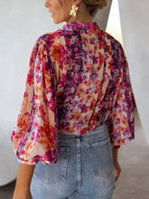 A vibrant floral print button up shirt with puffed sleeves collar in pink purple orange and cream lightweight fabric