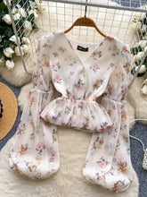 A delicate off-white chiffon floral print blouse with long puffy balloon sleeves and a ruched waistband