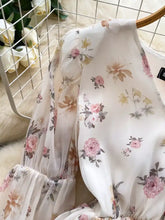A delicate white floral print chiffon balloon sleeve blouse with soft pink and beige blossoms on flowing fabric