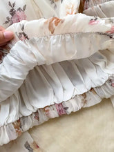 A delicate white chiffon floral print blouse with balloon sleeves and a soft ruffled hem in flowing fabric