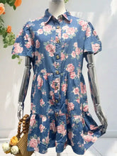 Floral print denim button-down mini dress with pink roses, green leaves, short puffed sleeves, and tiered ruffle hem