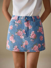 A light blue floral print denim mini skirt featuring vibrant pink rose patterns and a stylish print denim design