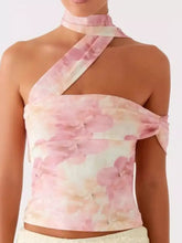 A delicate pink floral print halter neck cami with soft flowing fabric and asymmetrical design for elegant wear