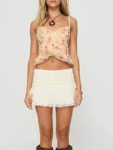 A delicate beige floral lace trim cami with thin straps and a ruffled hem perfect for layering or sleepwear