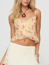 A delicate cream-colored floral print lace trim cami with thin spaghetti straps and a ruffled hem