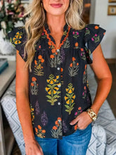 Black floral print short sleeve shirt with frilled v neck and orange-trimmed ruffled sleeves