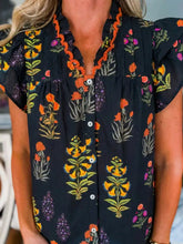 Black floral print short sleeve shirt with orange yellow blossoms and frilled v neck embroidered collar