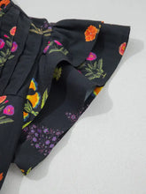 Black floral print short sleeve shirt with frilled v neck and lace trim featuring orange pink and purple blossoms