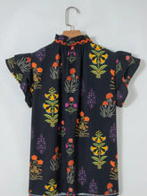 Black blouse frilled v neck short sleeve shirt with vibrant orange yellow purple green floral pattern and lace trim neckline