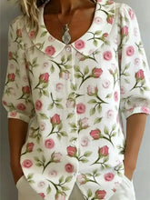 White blouse with delicate rose and green vine pattern featuring a peter pan collar and three-quarter sleeves