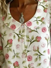White blouse with delicate pink rose and green leaf pattern featuring a classic peter pan collar floral print shirt
