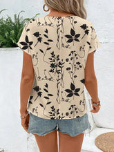 Beige short-sleeved floral print round neck blouse featuring a black botanical design for casual wear