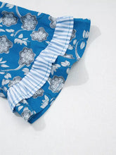 Floral print ruffle sleeve blouse in blue fabric with floral pattern and light blue and white striped ruffled hem
