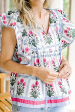 Floral print ruffle sleeve blouse with pink flowers green stems on white background and bright pink hem