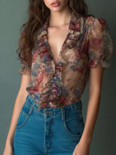 Floral print ruffle trim blouse in sheer pastel fabric features ruffled puff sleeves and a floral pattern