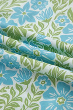 Floral print ruffled color block trim half sleeve blouse with blue and green floral patterned fabric on white background