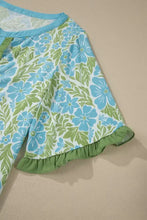 A light blue and green floral print blouse features ruffled color block trim with a matching collar and half sleeves