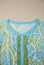 Floral print ruffled color block trim half sleeve blouse in light blue and green with a ruffled front panel