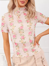 A delicate pink floral print sheer mesh top with short flutter sleeves and a high neckline