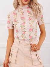 Delicate pink floral print sheer mesh top with short sleeves and high neckline featuring a sheer mesh overlay