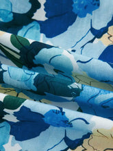 Floral print short puff sleeve v neck blouse in blue and green fabric with soft flowing folds