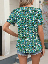 A vibrant blue and green floral print short sleeve blouse with ruffled neckline perfect for casual wear