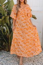 Woman in floral print smocked V neck maxi dress in orange and white