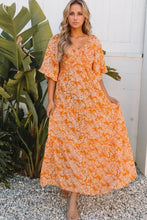 Woman in floral print smocked V neck maxi dress in orange and white