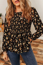 Black floral print smocked waist long sleeve blouse with peplum hem and fitted bodice for elegant wear