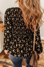 Black floral print smocked waist blouse with long sleeves and peplum hem for stylish casual wear