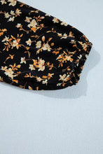 Black floral print smocked waist long sleeve blouse with delicate white and gold flowers and gathered elastic cuff