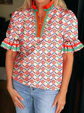 A vibrant floral print striped detail v neck ruffled short sleeve blouse with colorful blooms on off white fabric