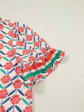 A vibrant floral print ruffled short sleeve blouse with v neck and striped detail in red pink blue on cream background