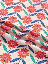 Cream-colored floral print neck ruffled short sleeve blouse with red-orange flowers and green-blue leaves