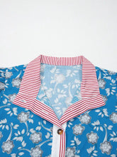 Blue floral blouse with red and white striped trim button neck and matching button placket short sleeve design