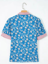 Blue floral print blouse featuring a red and white striped trim button neck with short sleeves for elegant wear